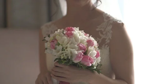 Young beautiful dark-haired bride with bouquet of tulips and freesias Stock Footage 94760134