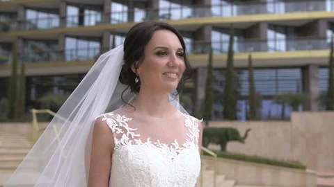 Young beautiful dark-haired smiling bride walking on the hotel territory Stock Footage 94217698