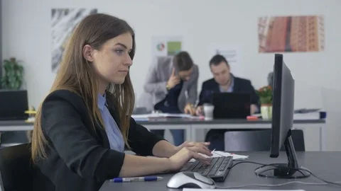 Young beautiful employee in a jacket working in the office Stock Footage 73991996