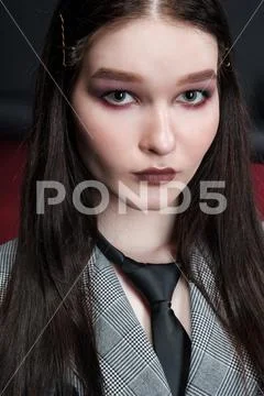 Young beautiful female fashion model in a business stylish suit on a red and Stock Photos