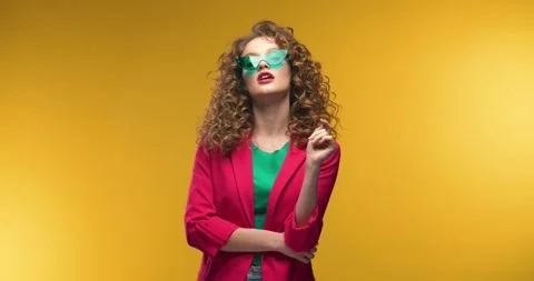 Young Beautiful female Model posing on Camera Standing over Yellow Background Stock Footage 145437109