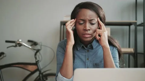 Young beautiful female office worker experiencing headache while sitting at work Stock Footage 148242515