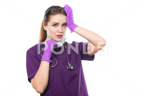 Young beautiful female sad doctor in medical mask and sterile gloves on white Stock Photos
