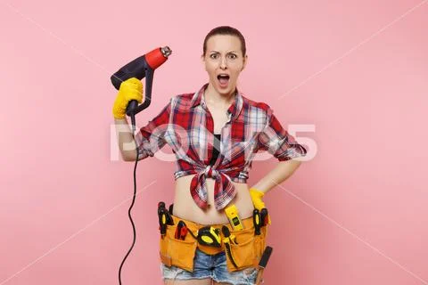 Young beautiful fun handyman woman in plaid shirt, denim shorts, kit tools belt Stock Photos