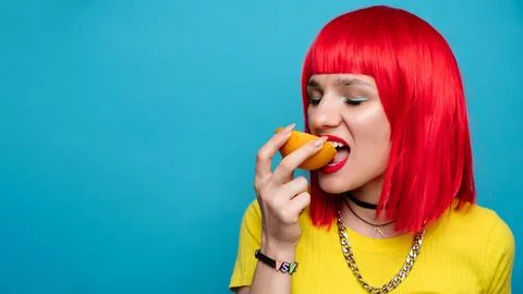 A young beautiful funny model bites off a slice of orange. Healthy vitamin food Stock Photos