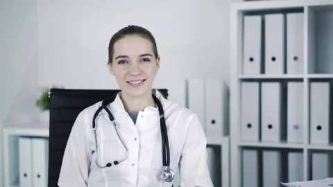 Young beautiful general practicer is twisting on the chair and smiling. Stock Footage 72926580