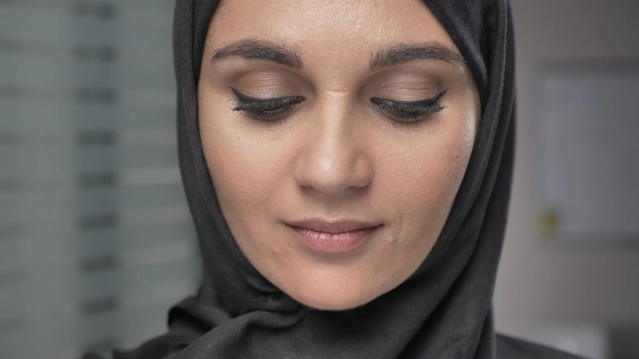 Video Young beautiful girl in black hijab smiling and looking at camera. Portrait ~ 86080954