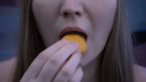 Young beautiful girl eats macaroon in super slow motion Stock Footage 96189468