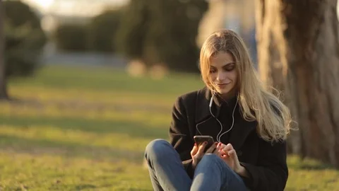 Young beautiful girl in headphones at sunset Stock Footage