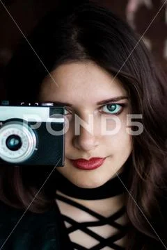 Young beautiful girl holding a camera Stock Photos