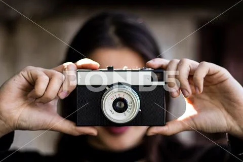 Young beautiful girl holding a camera Stock Photos
