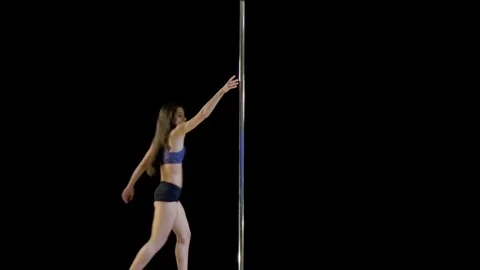 Young beautiful girl performs complex movements on the pylon Stock Footage 78223063