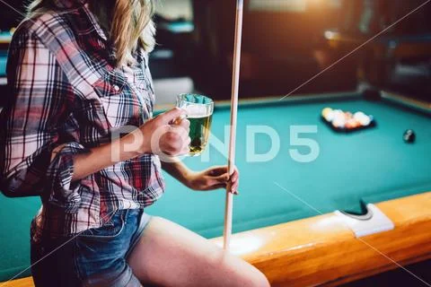 Young beautiful girl is playing billiards. Pleasant pastime, rest, entertainment Stock Photos