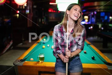 Young beautiful girl is playing billiards. Pleasant pastime, rest, entertainment Stock Photos