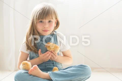 Young beautiful girl, playing with little newborn chick at home Stock Photos