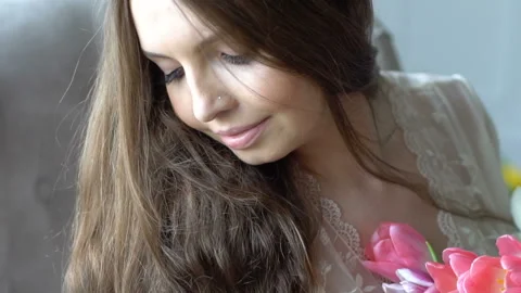 A young beautiful girl posing on a camera with flowers. Full HD Stock Footage 88779695