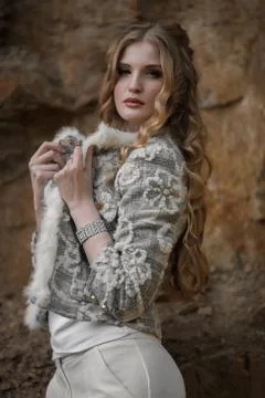 Young beautiful girl posing at the camera in a suit on a granite background Stock Photos