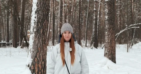 Young beautiful girl, red-haired beauty smiles, laughs, stands in park, winter Stock Footage 125902853