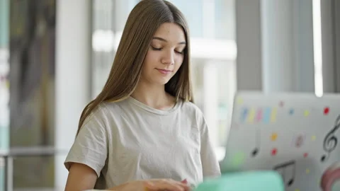 Young beautiful girl student using laptop studying at library Stock Footage 247387352