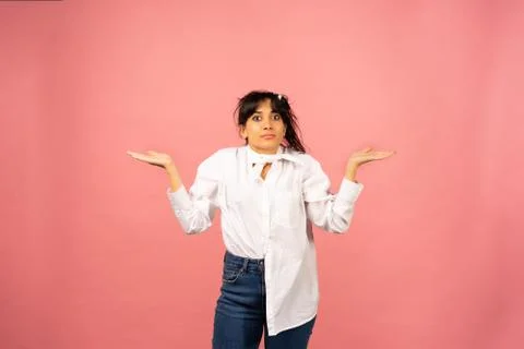 Young beautiful girl in a white shirt posing for a photo on a pink background Stock Photos