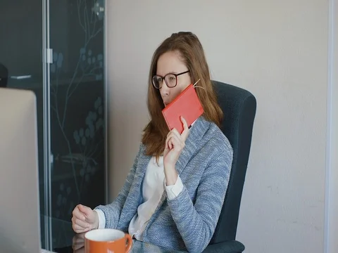 Young beautiful girl working while drinking tea. Stock Footage 73571892