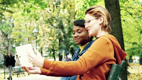 Young, beautiful girlfriends taking taking selfie photo with tablet in autumn pa Stock Footage 144630409