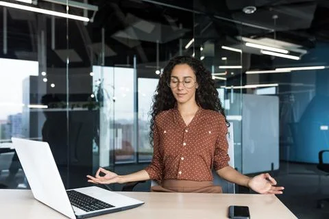 Young beautiful Hispanic web developer working inside office building, woman 写真素材