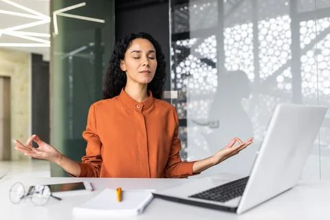 Young beautiful Hispanic web developer working inside office building, woman Foto stock