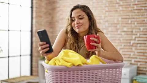 Young beautiful hispanic woman using smartphone drinking coffee leaning on .. Video stock 247376319