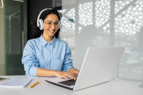 Young beautiful latin american programmer working inside office with laptop Stock Photos