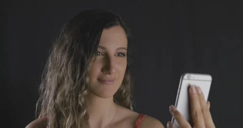 Young beautiful long haired lady looking her smartphone and being happy, succ Stock Footage 139824858