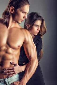 Young beautiful loving couple on a dark background. Focus on girl Stock Photos