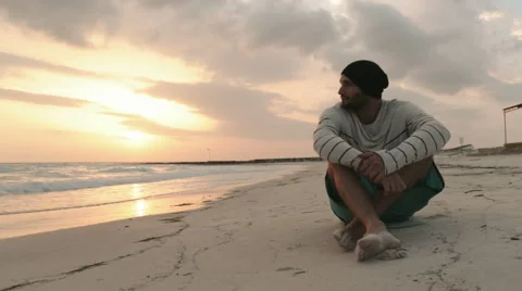 Young beautiful man relax on ocean beach seaside at sunrise or sunset 動画素材 64560656