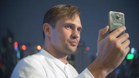Young, beautiful man using a smartphone and drinking a cocktail, on a bar Stock-Footage 86438713