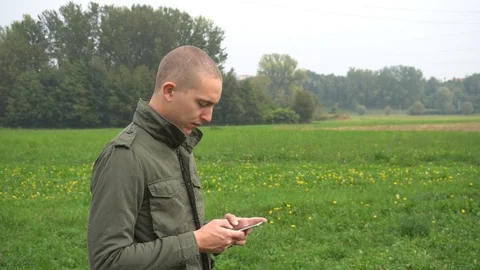 Young Beautiful Man Using the Smartphone in the Wild Stock Footage 96207397