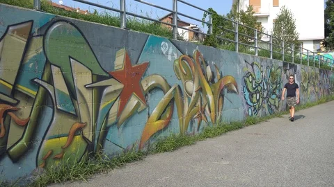 Young Beautiful Man Walking in front of Mural in a Big City, in Turin, Italy on Stock Footage 95289531