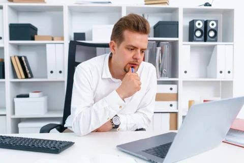 Young beautiful man work on computer sit at table in office smile Stock Photos