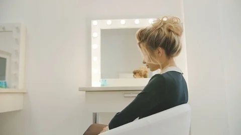 Young beautiful model after make up and hairdressing rotates in the white chair Stock Footage 74477215