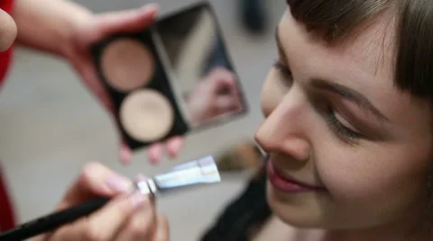 Young beautiful model being applied make up by a visagiste Stock Footage 48630112