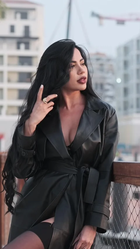 A young beautiful model with long black hair with good makeup fixes her hair. Stock Footage 334536807