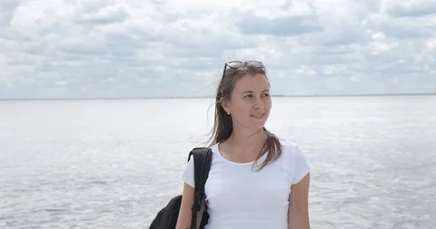 Young beautiful model pose in front of camera, she stand on shore of vast lake Stock Footage 118301385