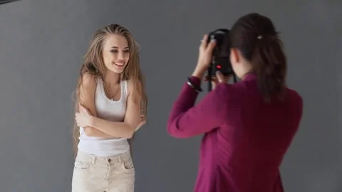 Young beautiful model posing for professional photographer in studio Stock Footage 79709620