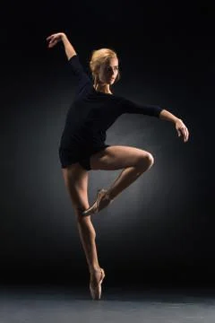 Young beautiful modern style dancer posing on a studio background Stock Photos