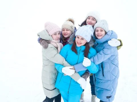 Young beautiful mother with daughters stands embracing on a winter day on a walk Stock Photos