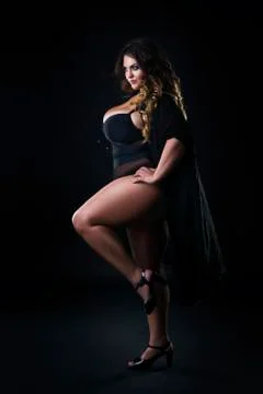 Young beautiful plus size model in underwear, xxl woman on black Stock Photos