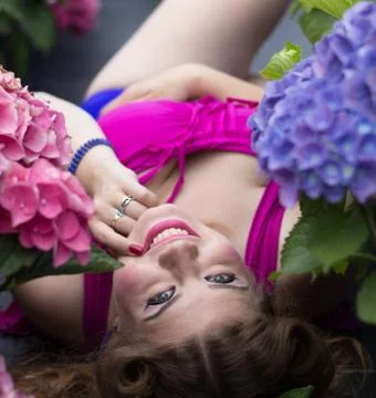 Young beautiful plus size model lying in flowers Foto stock