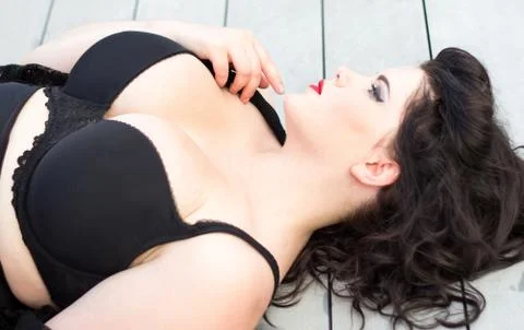 Young beautiful plus size model  lying on the wooden background, xxl woman Stock Photos