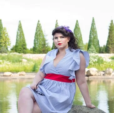Young beautiful plus size model in dress near the lake Stock Photos