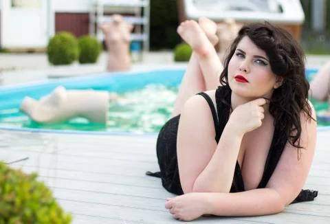 Young beautiful  plus size model  lying near the outdoors pool Foto stock