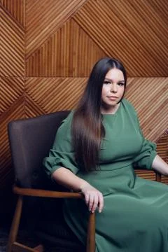 Young beautiful plus size model in a dress, xxl woman portrait on wooden studio Foto stock